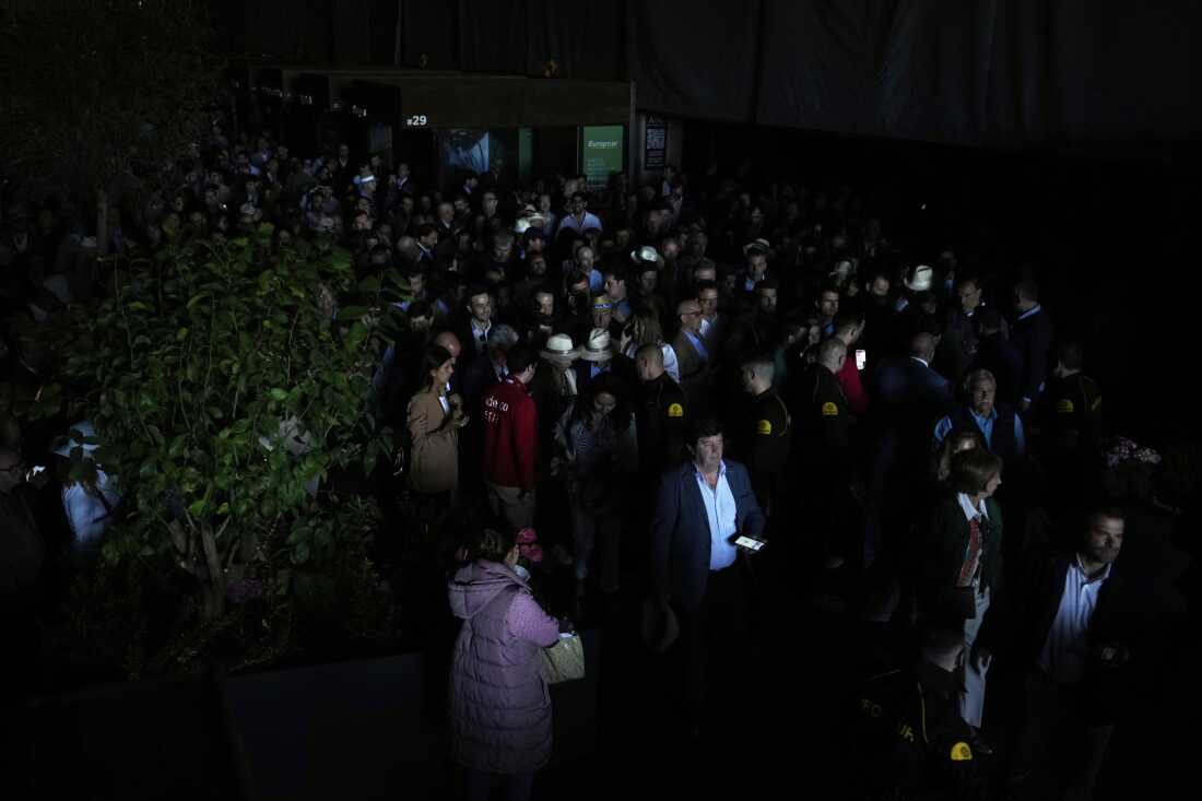 Spectators roam inside the Madrid Open tennis tournament venue during a general blackout in Madrid, Monday, April 28, 2025. (AP Photo/Manu Fernandez)